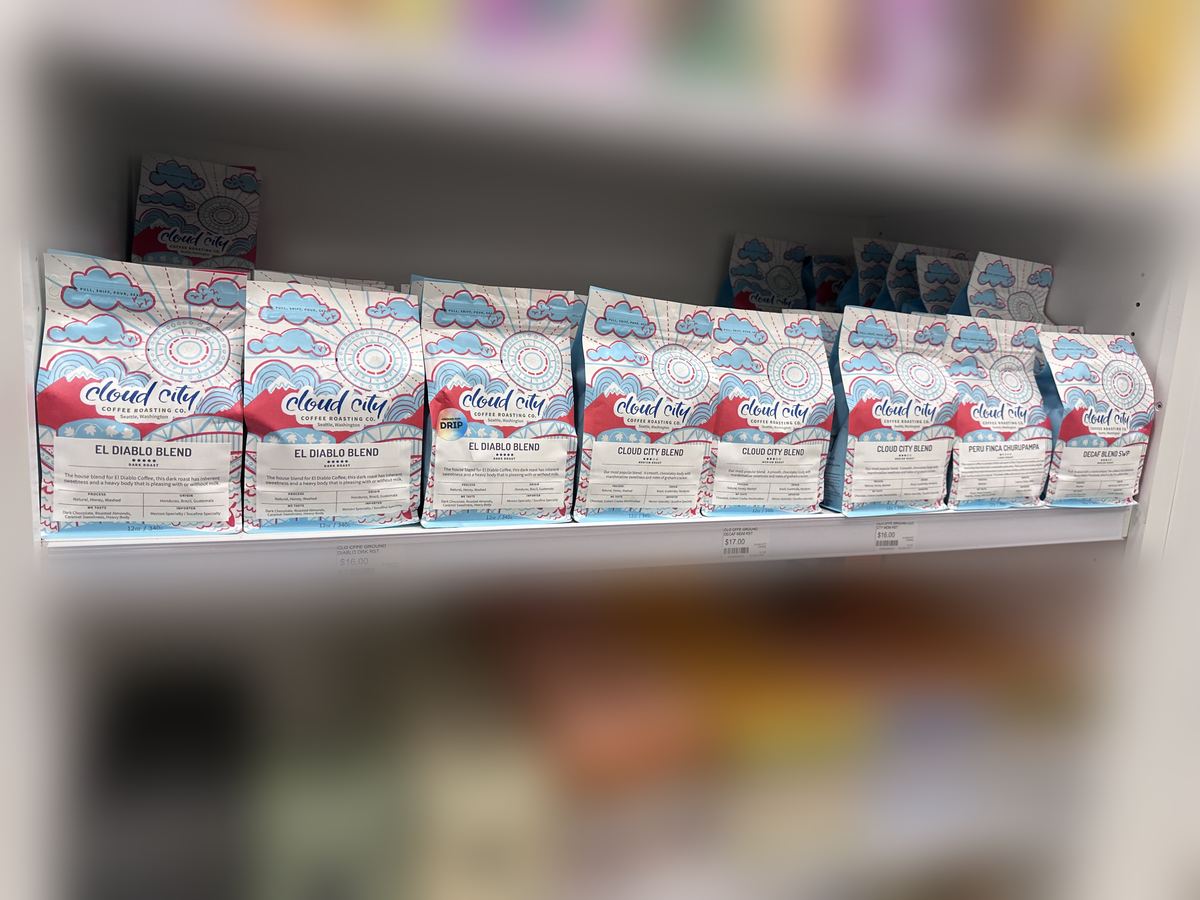 Cloud City Coffee bags facing out on a grocery shelf, including El Diablo Blend, Cloud City Blend, and Peru Finca Churupampa